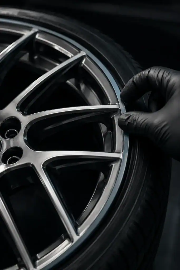 Technician fitting a colour-matched protective strip to the outer rim of an alloy wheel