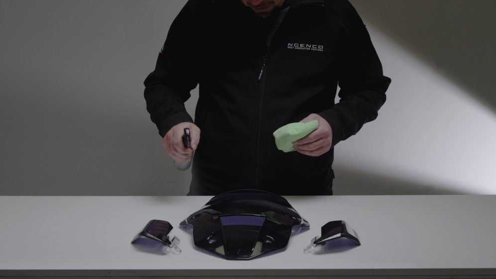 Ngenco technician cleaning motorcycle panels with a cloth after application