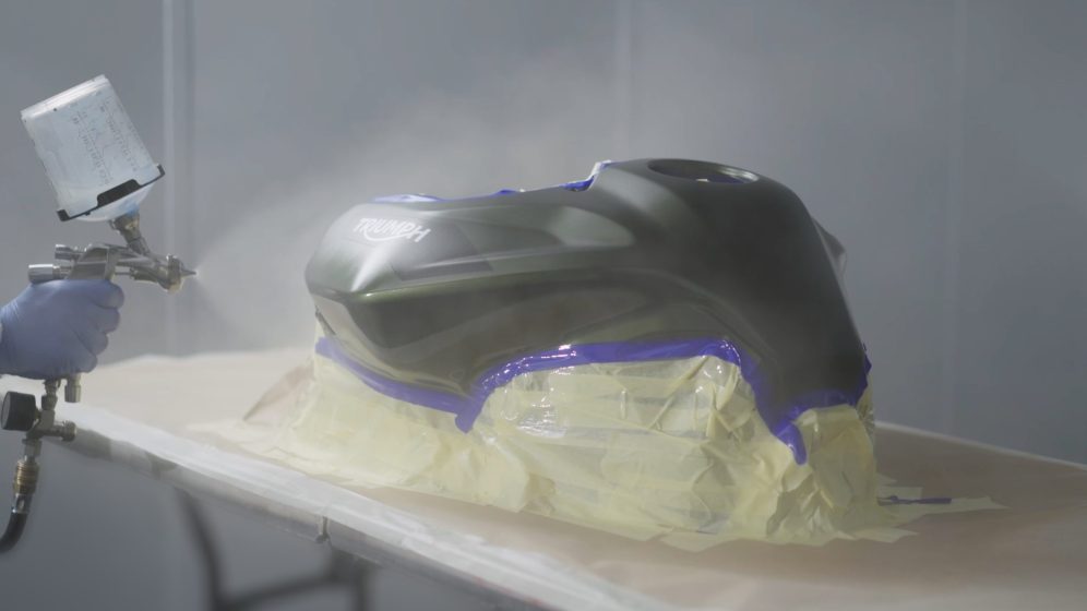 Spray application to a masked motorcycle fuel tank