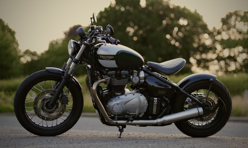 Green and cream Triumph Bobber photographed side-on outdoors