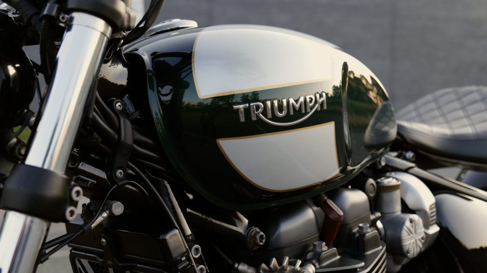 Close-up of the glossy green and cream Triumph motorcycle tank
